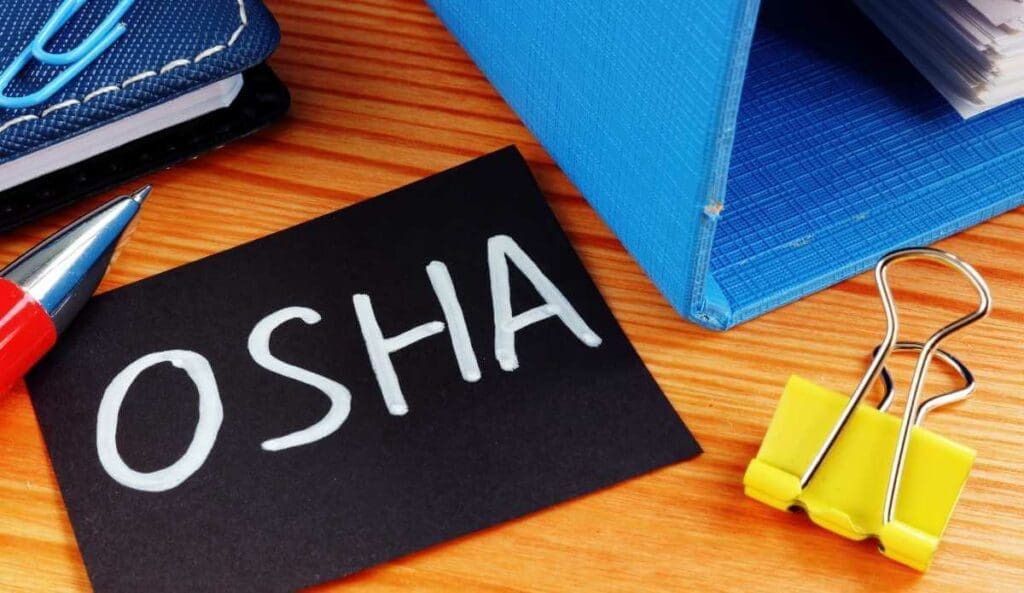 Close-up of OSHA training handbook and binders and safety training materials.
